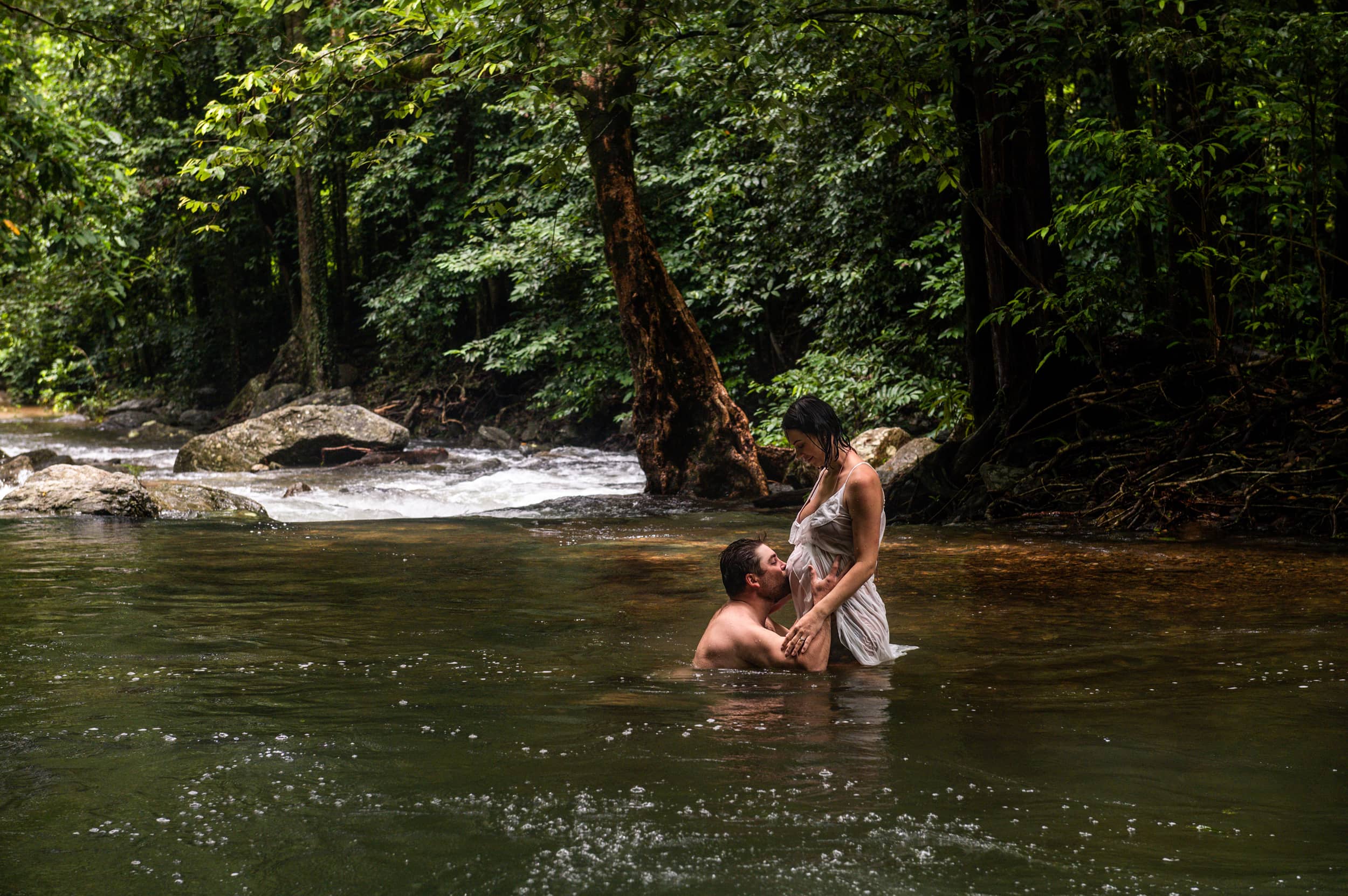 Mother-to-be and husband in a serene underwater maternity portrait in Cairns in a creek