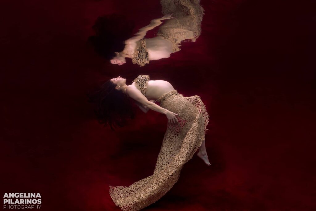 underwater maternity portrait on a red backdrop