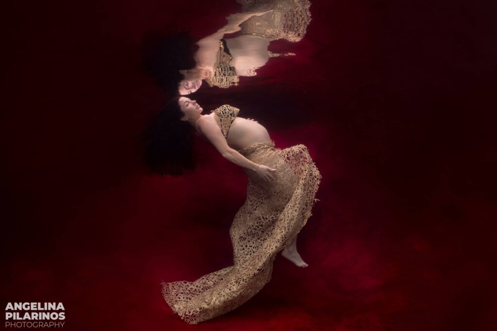 underwater pregnancy photoshoot on a red backdrop