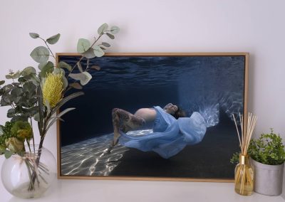 Pregnant woman in flowing blue dress during an underwater maternity photoshoot in Cairns printed and framed canvas.
