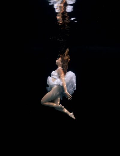 Underwater portrait of a woman on a black background