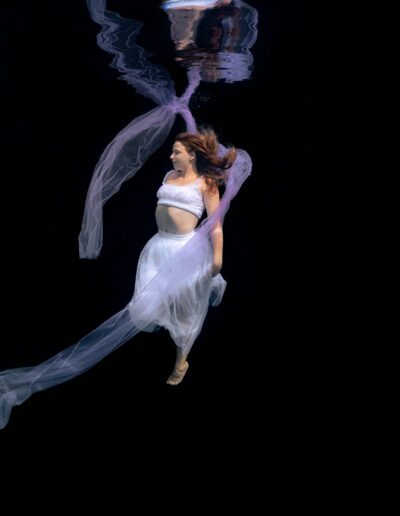 Underwater portrait of a woman on a black background