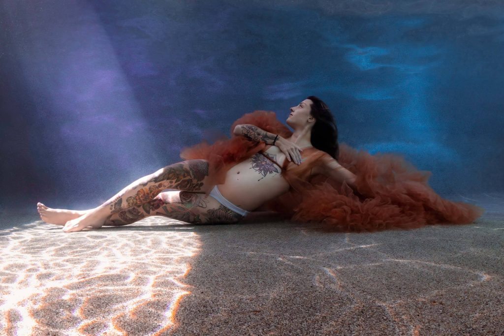 Mother-to-be in serene underwater maternity portrait in Far North Queensland