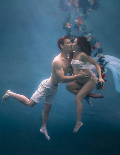Mother-to-be and husband in serene underwater maternity portrait in Port Douglas