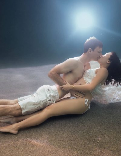 Couple embracing in love during romantic underwater maternity photography in Cairns